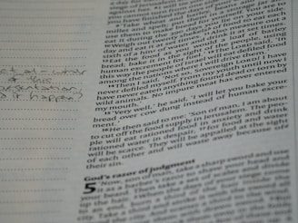 A close-up of a page from a book with printed text and handwritten notes in the margins. The text appears to be in English and consists of paragraphs, while the handwritten notes include a question.