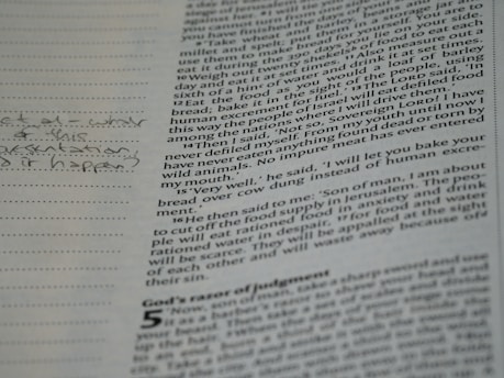 A close-up of a page from a book with printed text and handwritten notes in the margins. The text appears to be in English and consists of paragraphs, while the handwritten notes include a question.