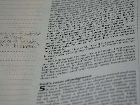 A close-up of a page from a book with printed text and handwritten notes in the margins. The text appears to be in English and consists of paragraphs, while the handwritten notes include a question.