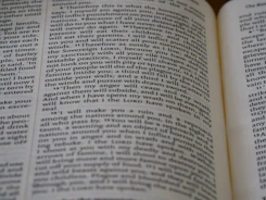 Close-up of a printing press producing religious books with gilded edges