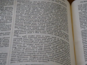 Close-up of a printing press producing religious books with gilded edges