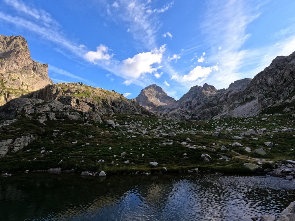 a body of water surrounded by mountains under a blue sky