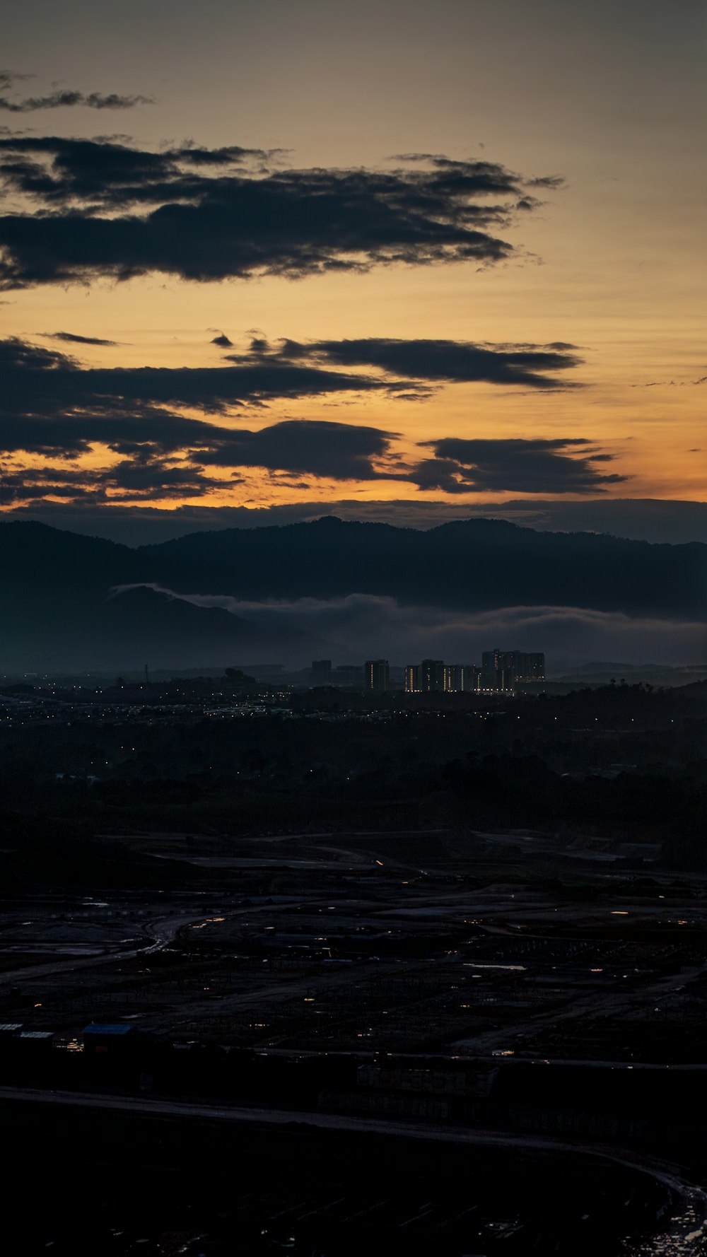 uma vista de uma cidade de uma colina ao pôr do sol