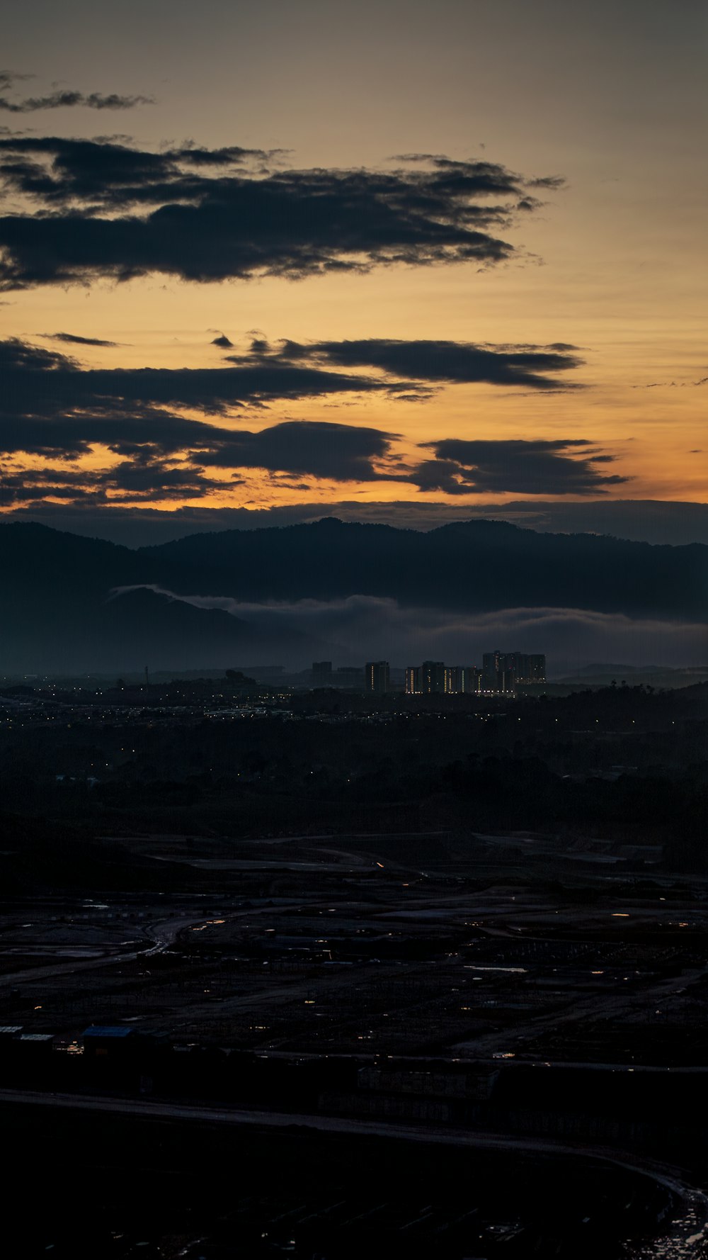 a view of a city from a hill at sunset