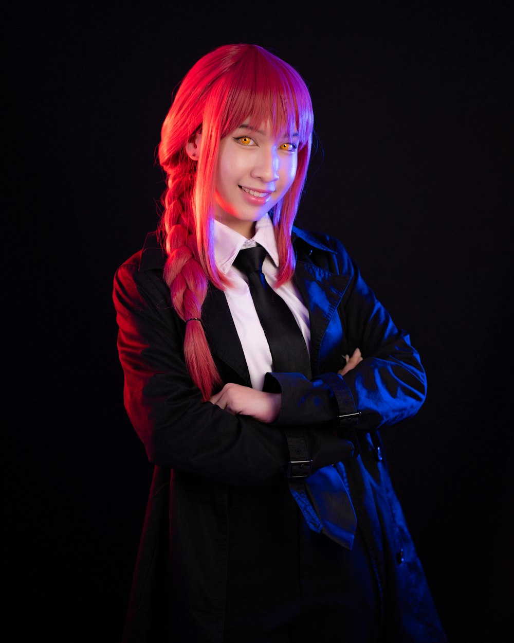 a woman with red hair wearing a black jacket and tie