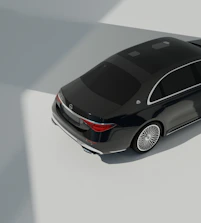 Shiny luxury car with reflections highlighting flawless paintwork in a dark studio.