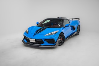 A sleek, midnight-blue luxury sports car gleaming under city lights, embodying speed and elegance.