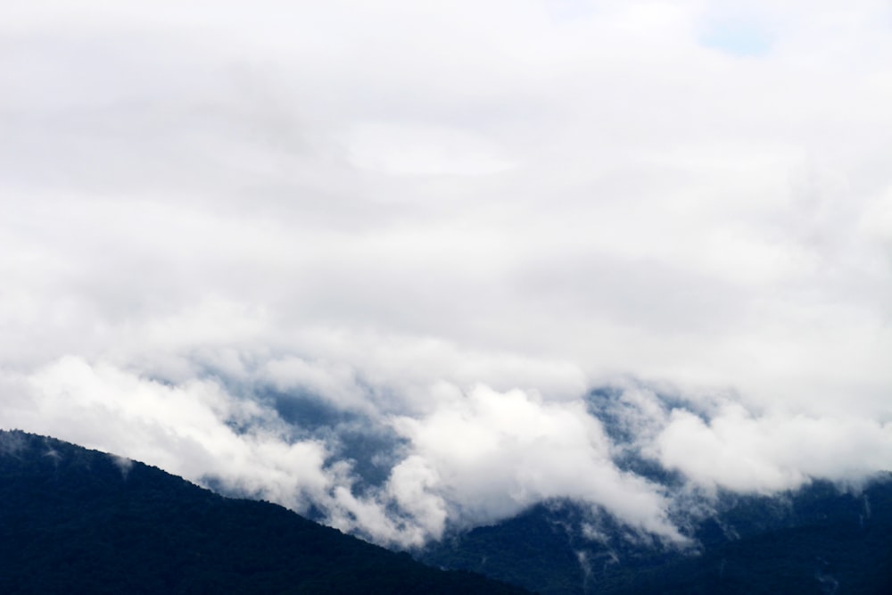 a plane flying over a mountain covered in clouds