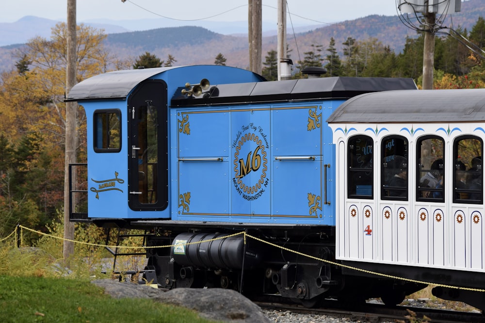 a blue and white train traveling down train tracks