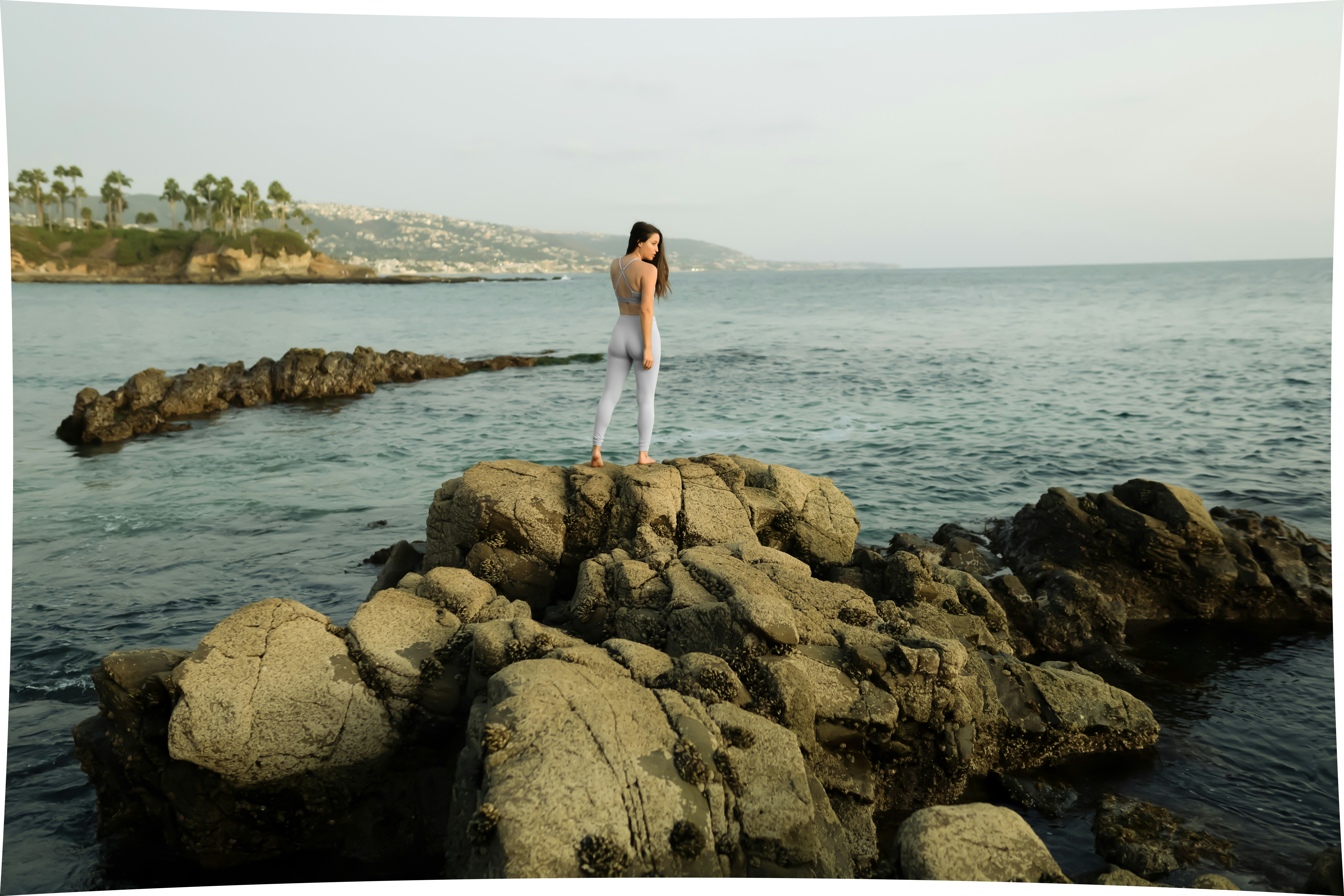 Un hombre parado en una roca junto al océano