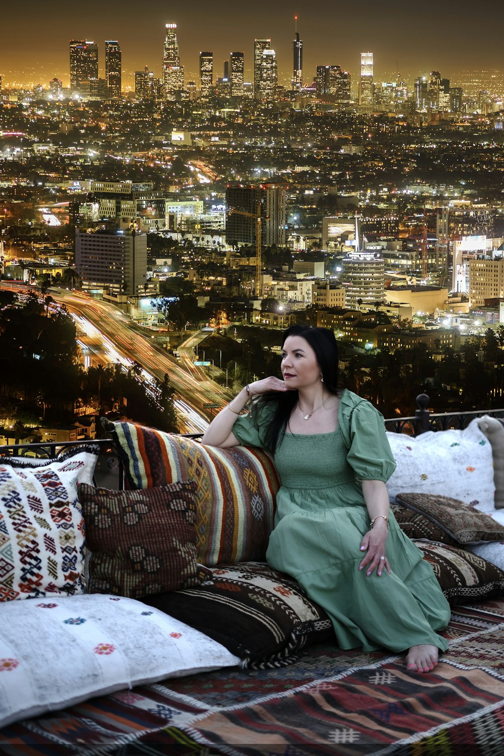 a woman sitting on top of a couch in front of a city