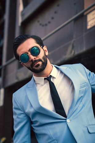 A stylish man wearing a tailored suit in an urban setting.