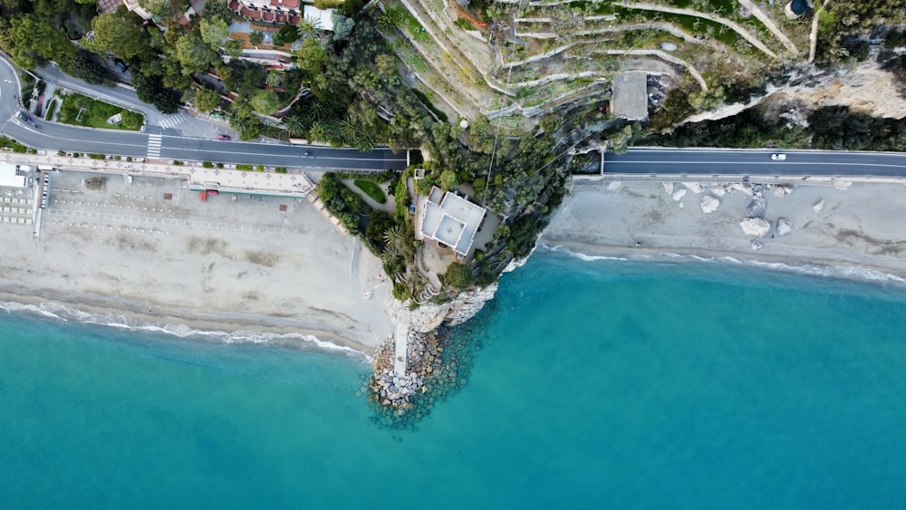 an aerial view of a road next to a body of water