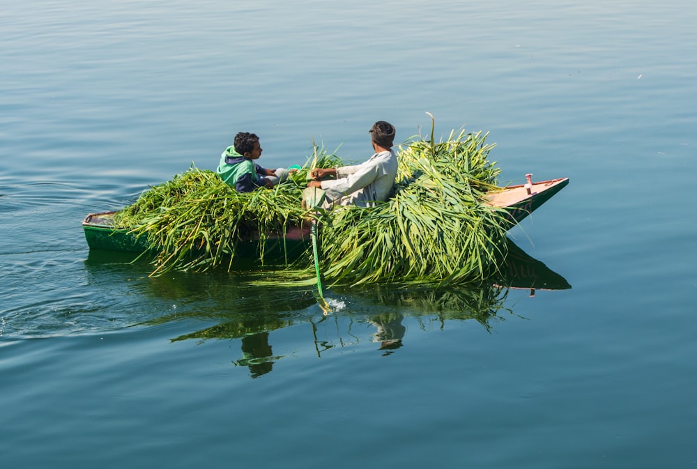 two people on a small boat filled with grass