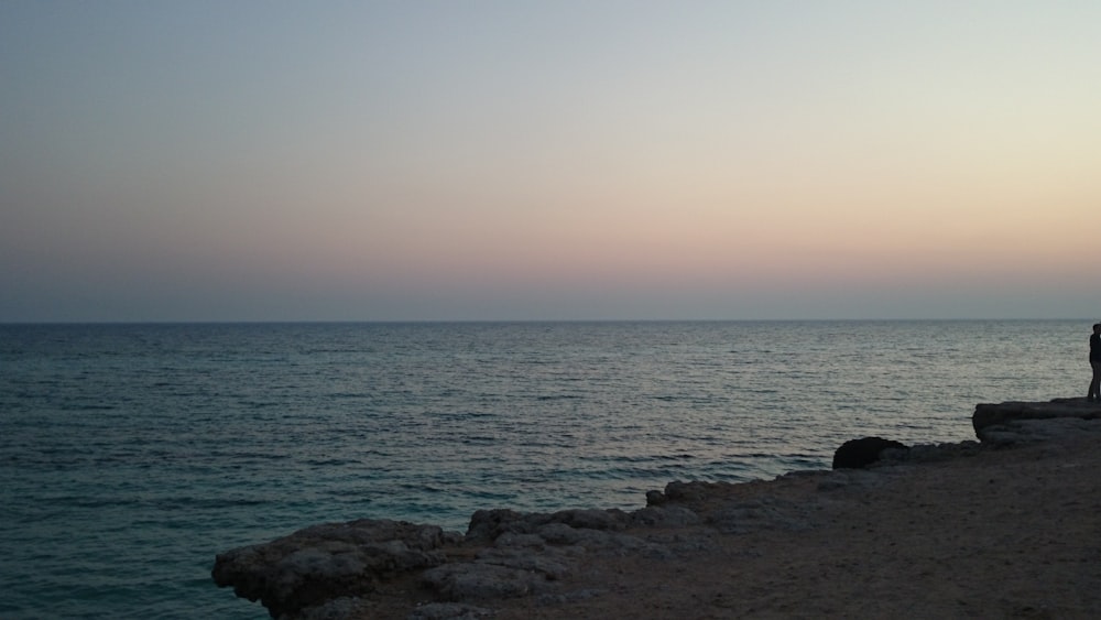 a person standing on a beach next to the ocean