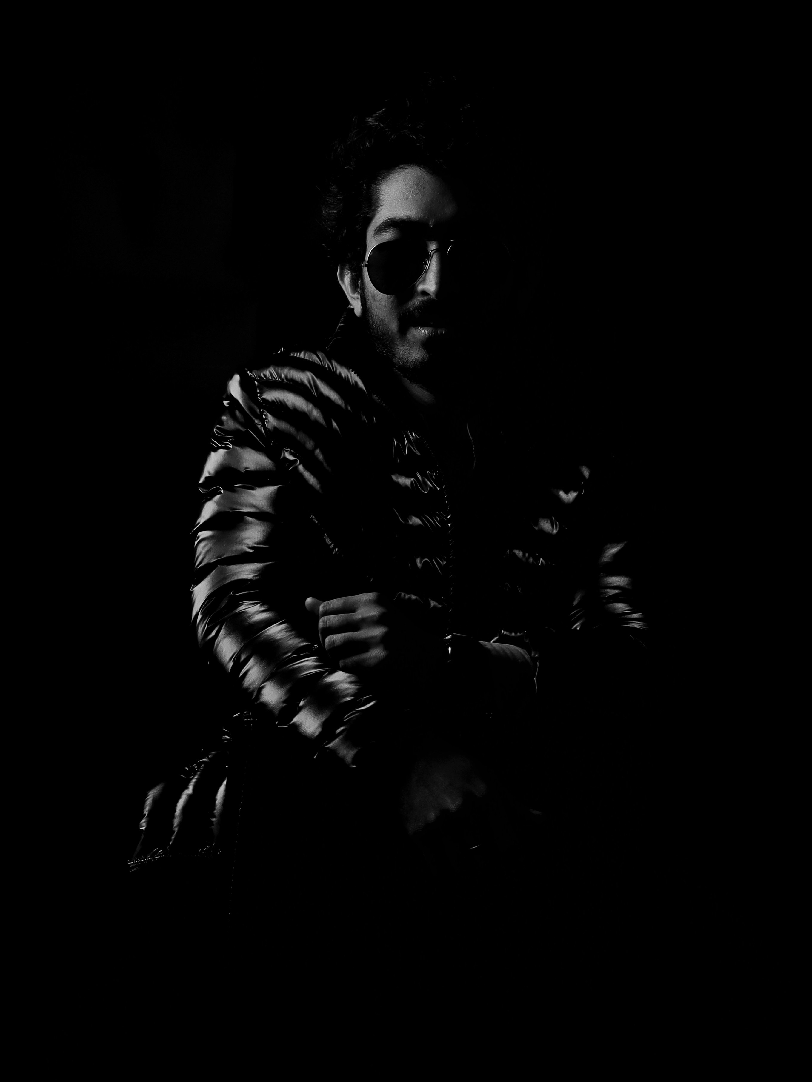 a man standing in the dark with his arms crossed