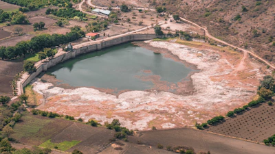 Technicians inspecting a modern water storage reservoir in a natural setting.