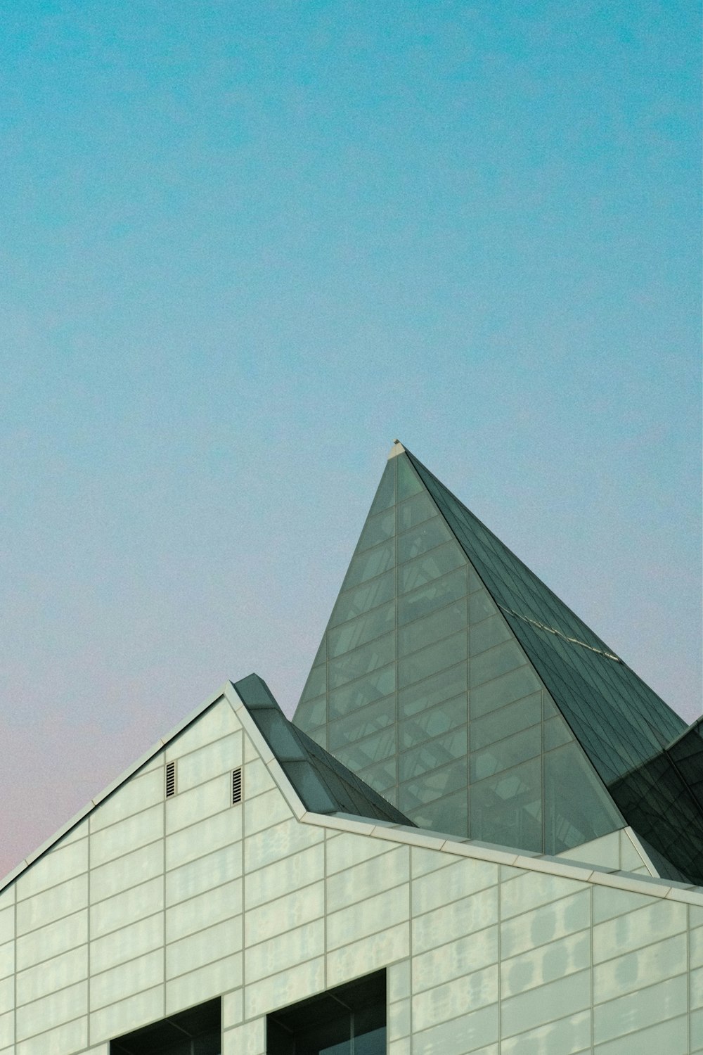 a plane flying over a building with a sky background