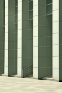 Modern dark green architectural facade with sleek lines and golden matte accents.