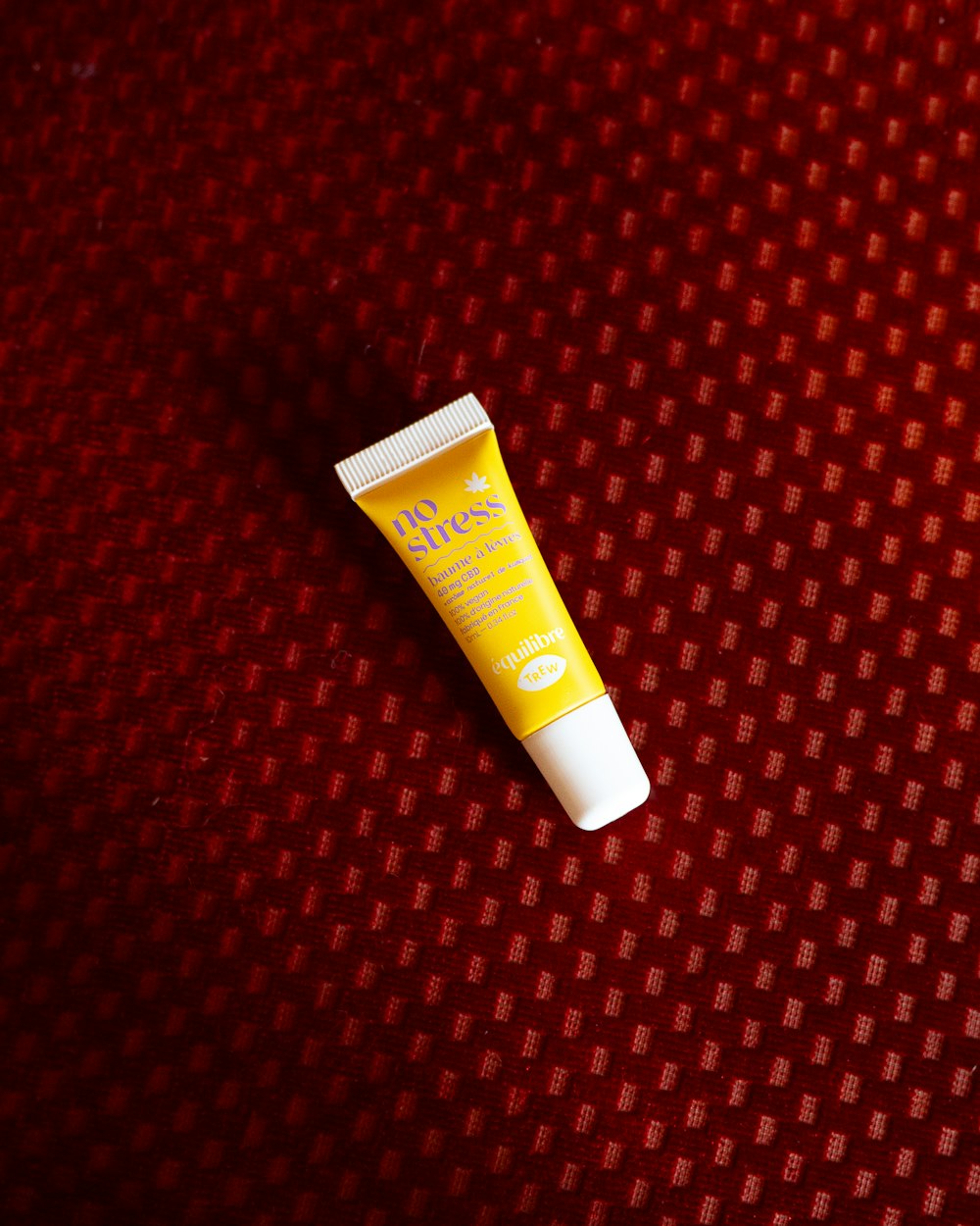 a tube of sunscreen sitting on a red surface