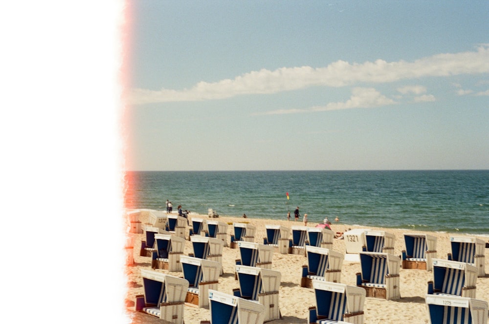 a group of beach chairs sitting on top of a sandy beach