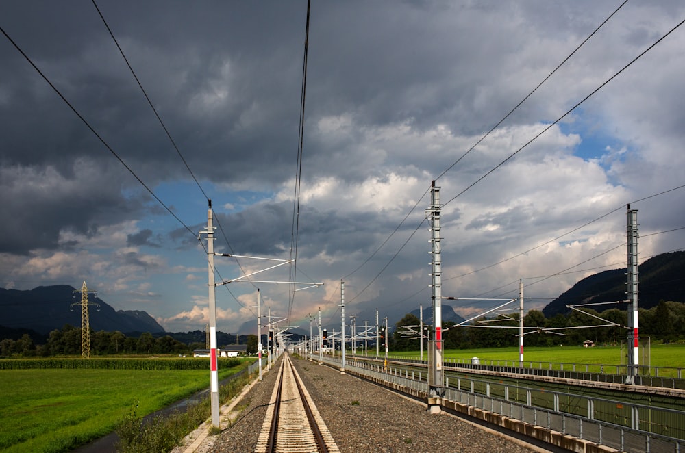 a train track running through a lush green field