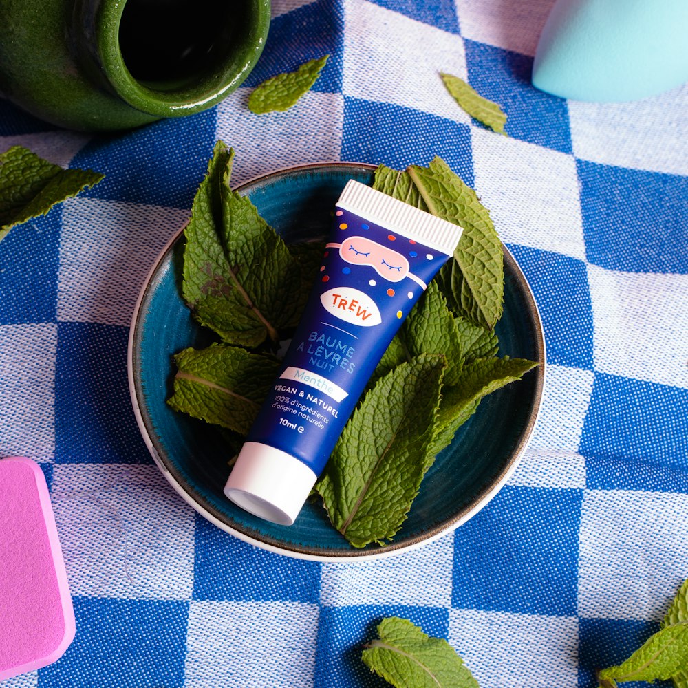 a bowl of mint leaves and a tube of lip balm