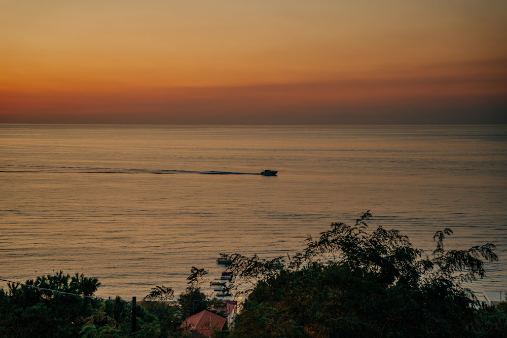 a boat is out on the water at sunset