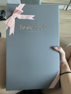 Luxcopper craft packaging box in matte black with copper foil logo on a cream fabric background