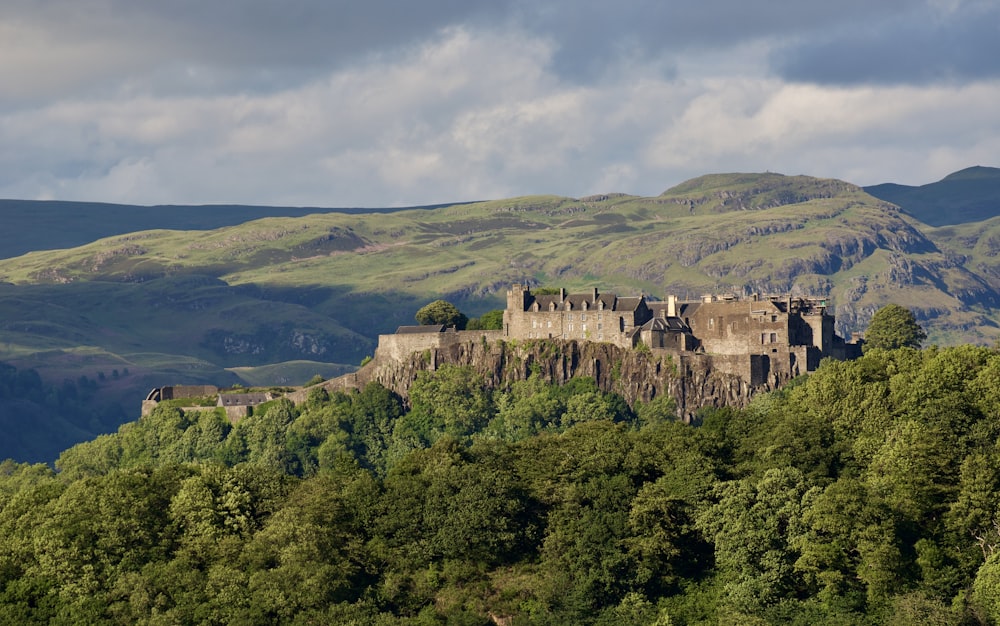 a castle sitting on top of a lush green hillside