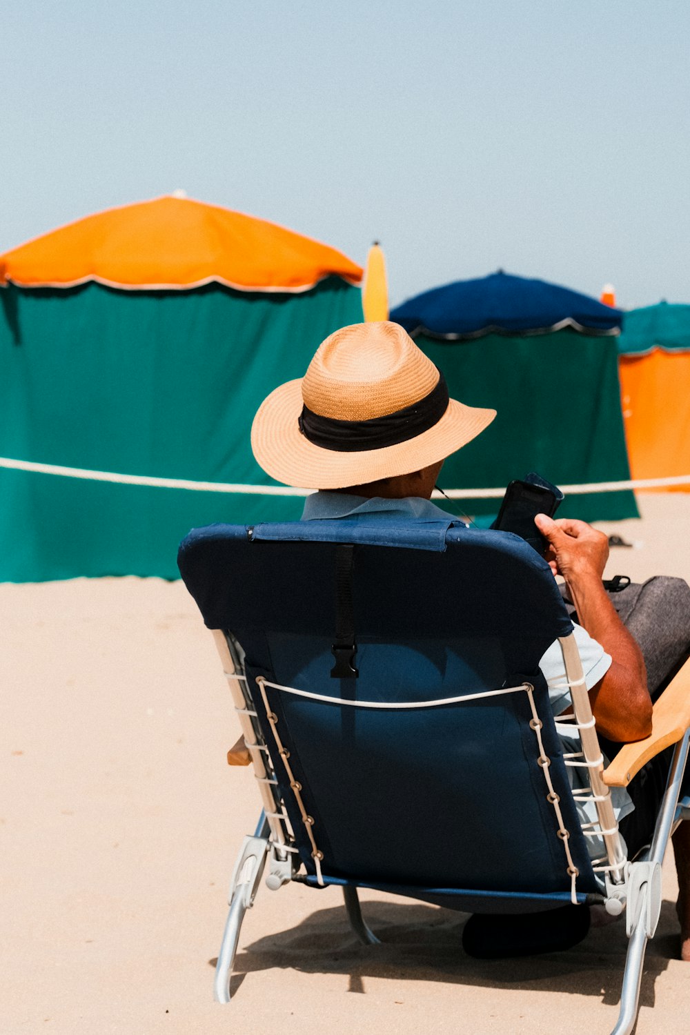 ein mann, der auf einem stuhl am strand sitzt