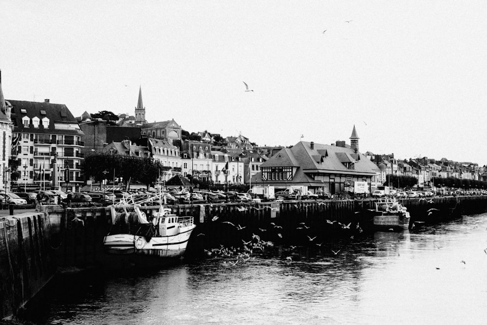 a black and white photo of a river with boats in it