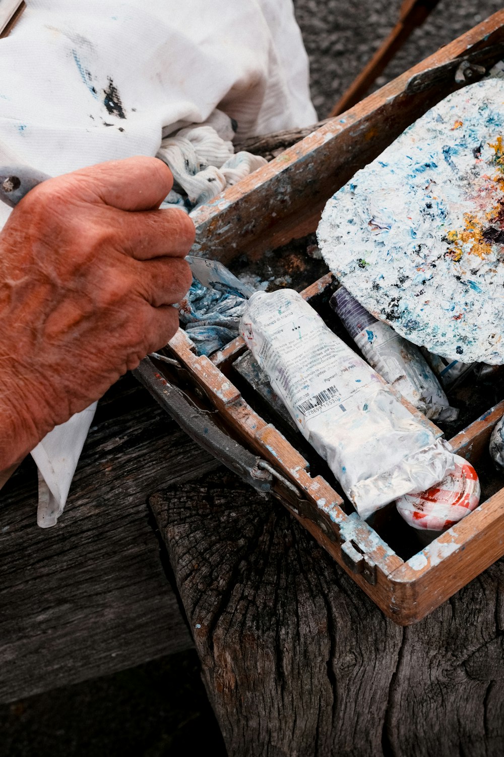 an old man is holding a box of paint