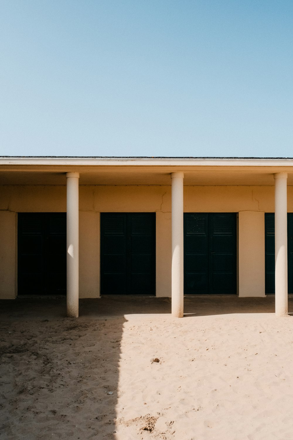 a row of garages sitting on top of a sandy beach