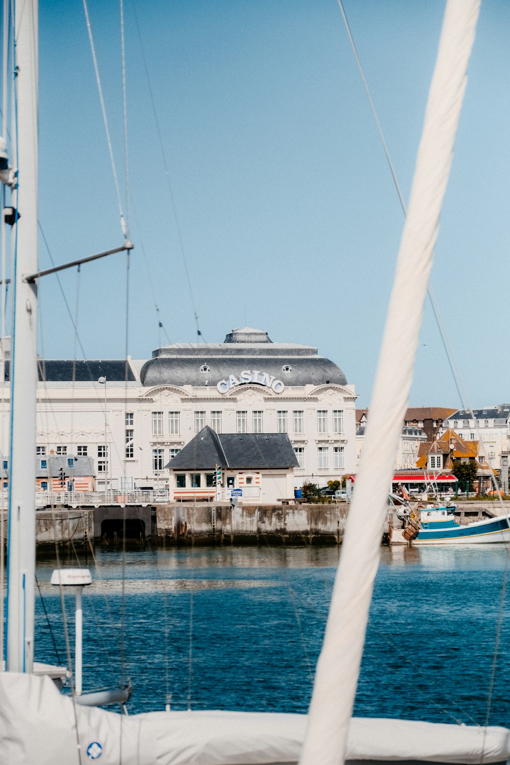 a sailboat in a harbor with a building in the background