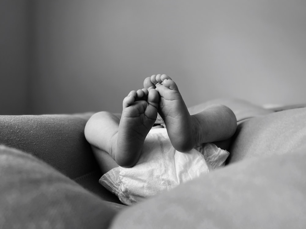 a black and white photo of a baby's feet