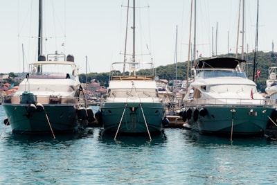 Sunset view of three premium yachts anchored side by side in Puerto Banús marina.