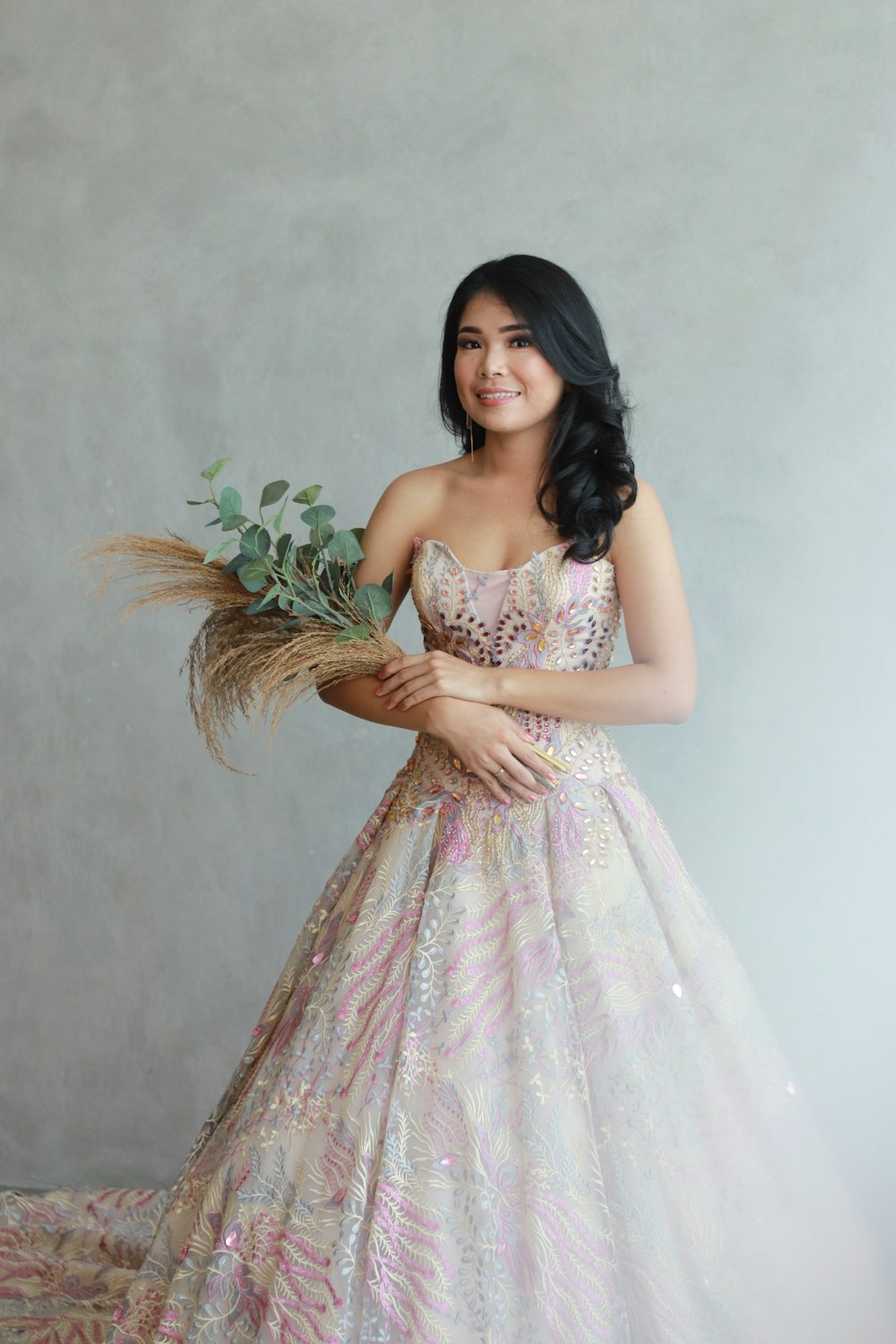 a woman in a dress holding a bouquet of flowers