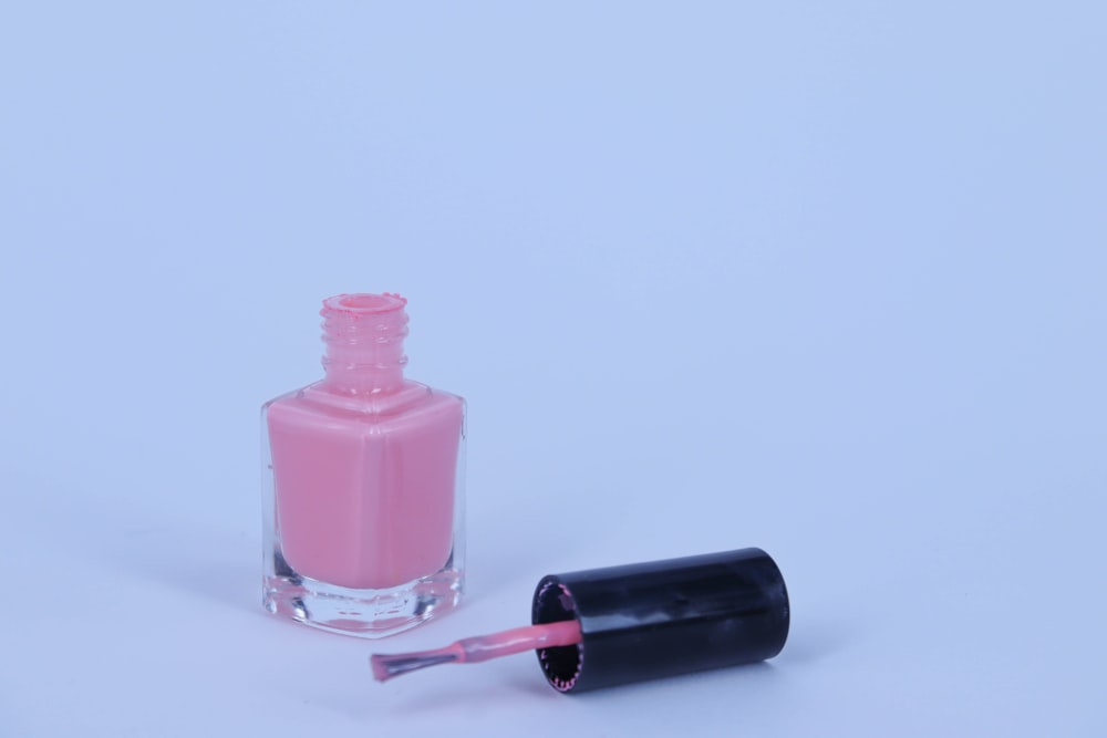 a bottle of pink nail polish next to a bottle of pink nail polish
