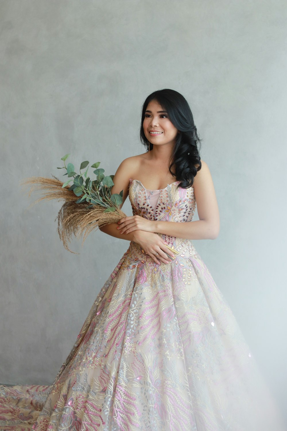 a woman in a dress holding a bouquet of flowers