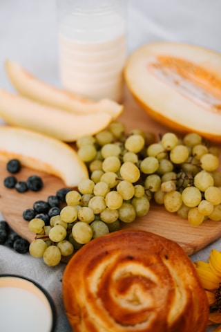 Close-up of fresh fruits and homemade pastries arranged on a vintage ceramic plate.