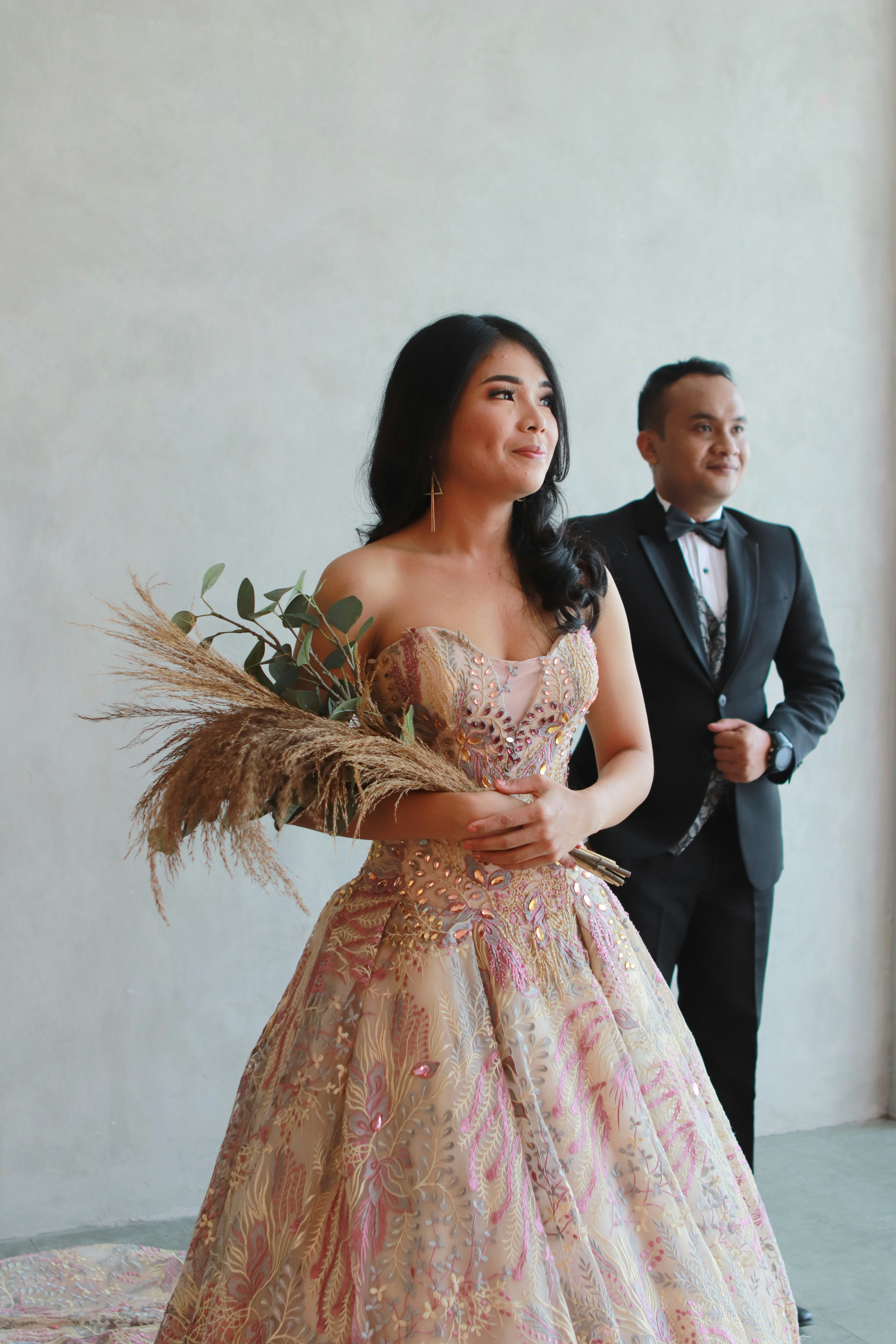 A woman in a dress standing next to a man in a tuxedo photo – Free ...