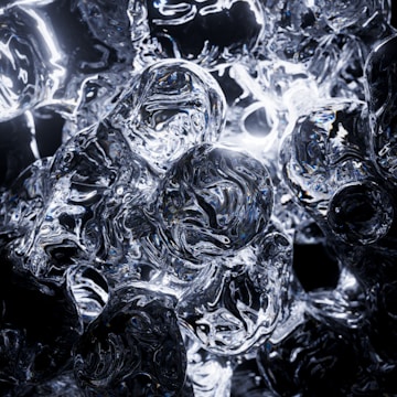 A complex arrangement of reflective, glass-like orbs and shapes interspersed with light, creating intricate patterns and reflections. The material appearance suggests a combination of transparency and gloss, enhancing the visual texture.