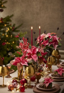 a table topped with plates and vases filled with flowers