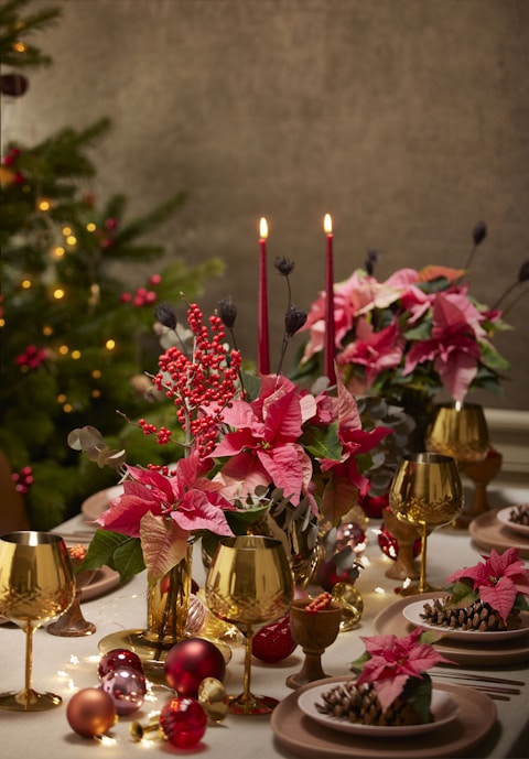 a table topped with plates and vases filled with flowers