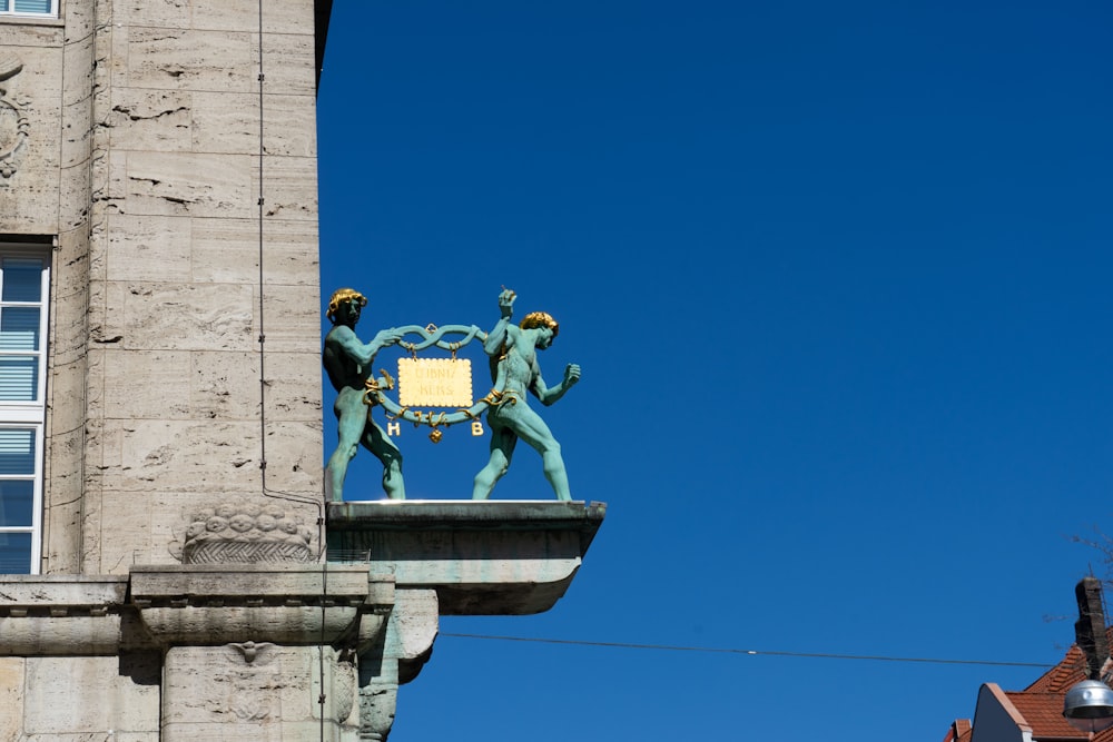 a statue of two men holding a sign on top of a building
