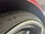 A close-up of a car tire with the 'Michelin' branding prominently displayed along with a small logo. The surrounding element of the car, possibly a wheel arch, is visible, and the tire appears new with clean tread patterns.