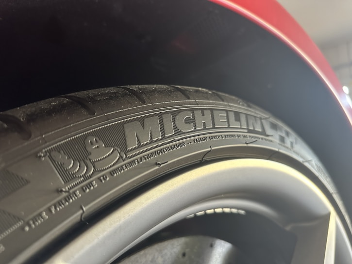 Close-up of a shiny new tire with a red price tag highlighting a special discount.