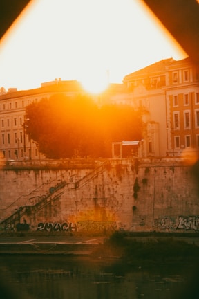 Sunlight casting warm hues over a neatly marked NA plot with visible boundary stones and a distant cityscape.