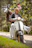 Happy couple riding a double-seater scooter along a sunny coastal road in Tonga.